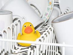a yellow rubber duck sitting in a dishwasher